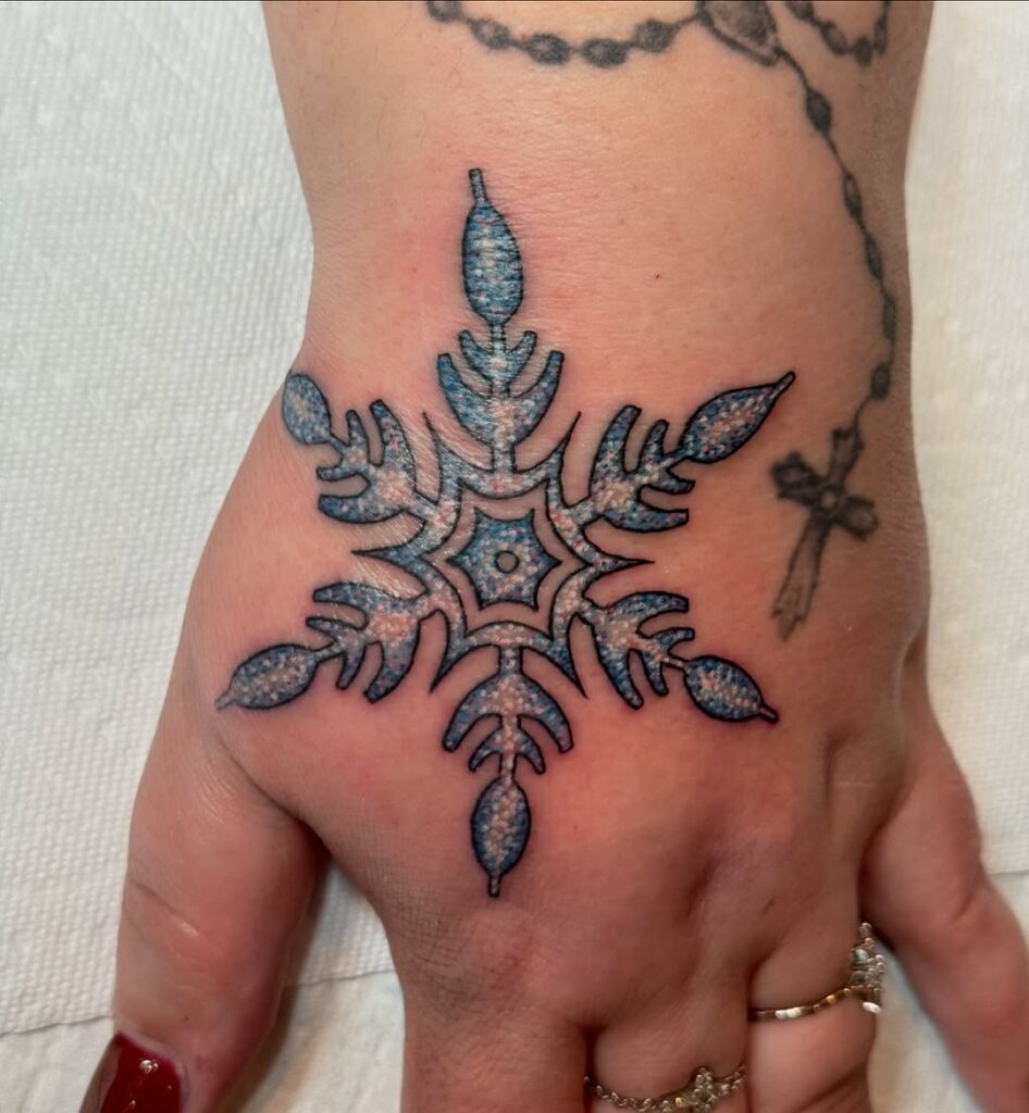 Tatuaggio a mano con fiocco di neve glitterato