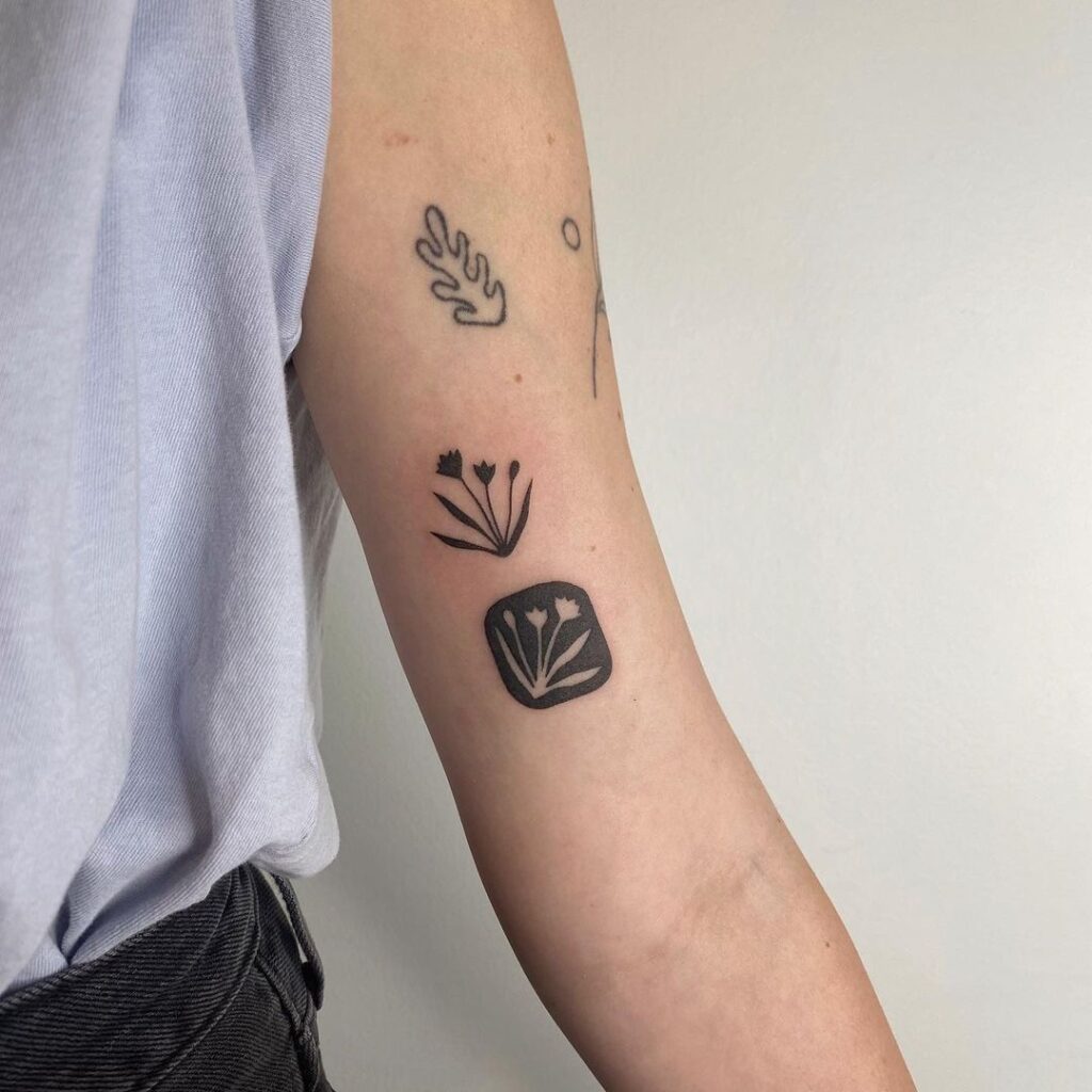 Tatuaje de flores pequeñas en espacio negativo