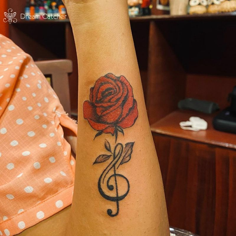 Tatuagem de rosa e notas de música