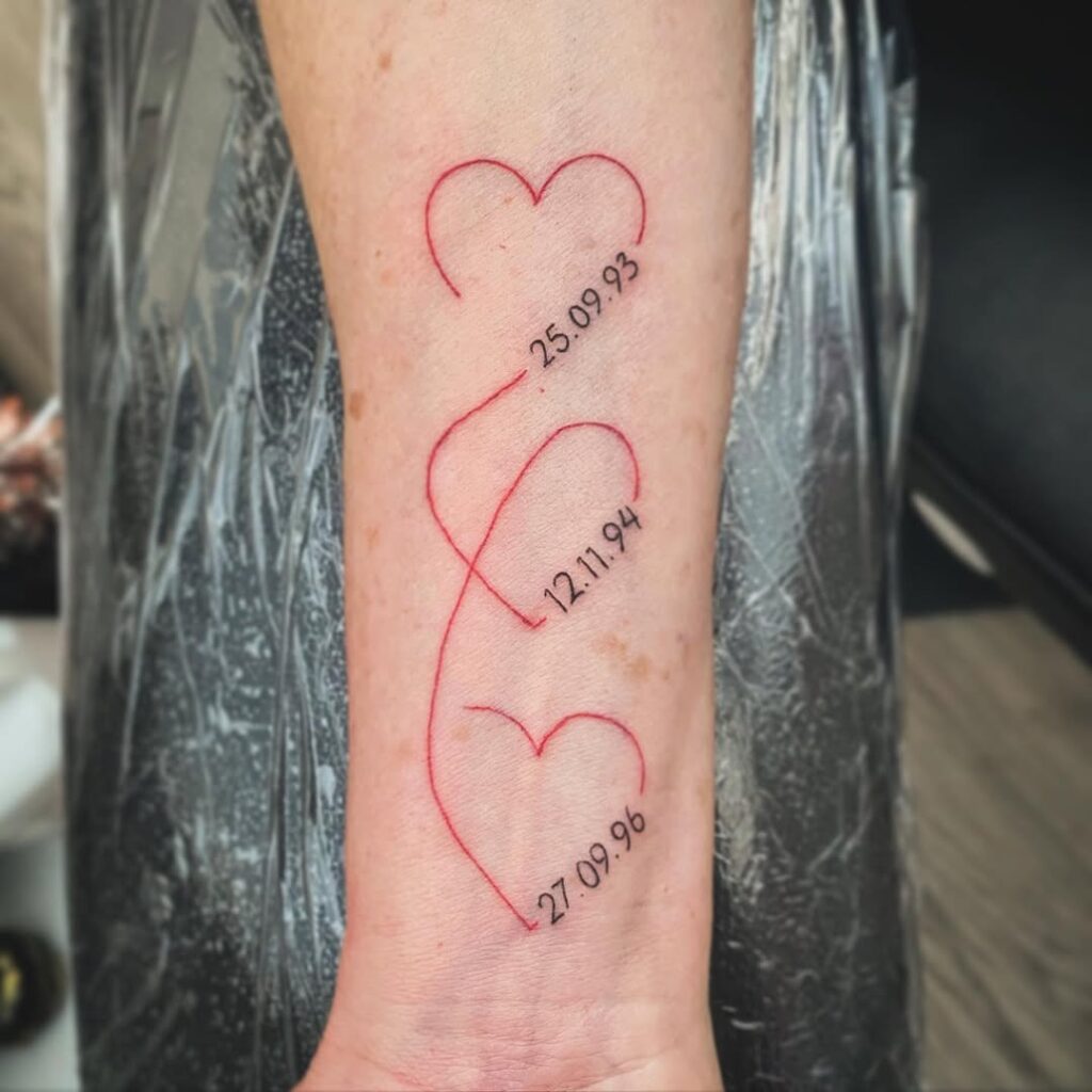 Tatuaje de fechas de nacimiento en corazones conectados