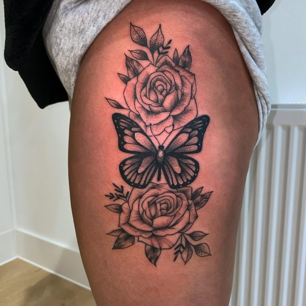 Tatuaje de mariposa y rosas en la cadera