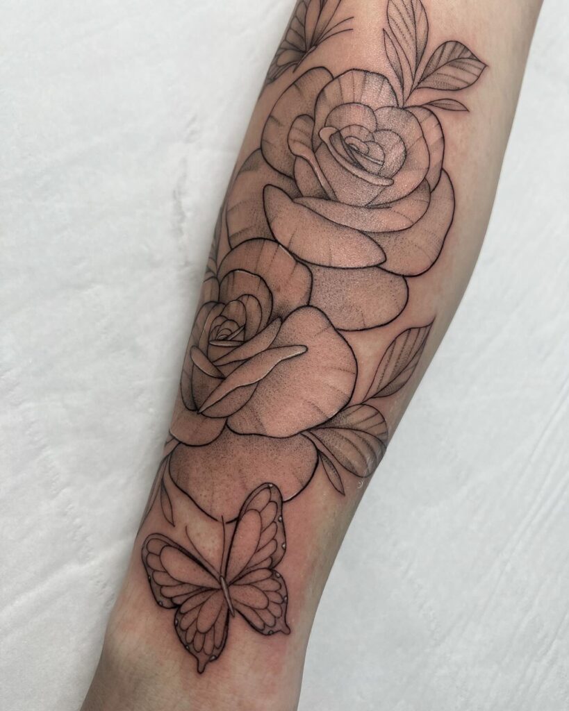 Tatuaje de rosas y mariposas en el antebrazo